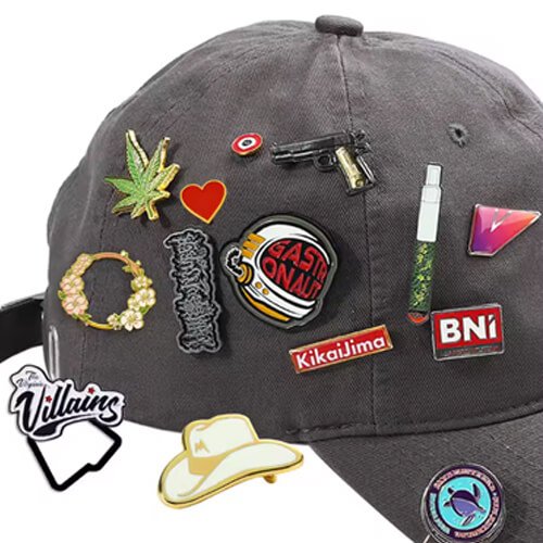 Gray baseball cap decorated with many colorful enamel pins, including symbols, logos, and cartoon-style graphics.